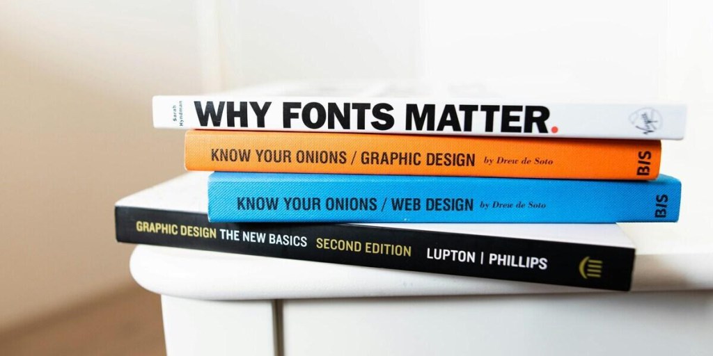 Four assorted books on a white table