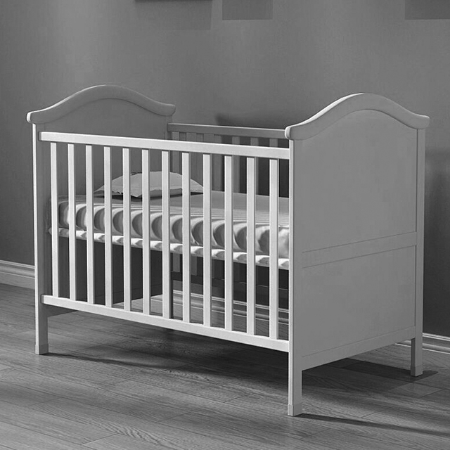 white wooden cot bed with mattress