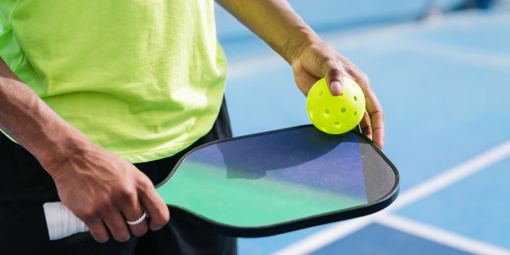 Person holding pickleball paddle
