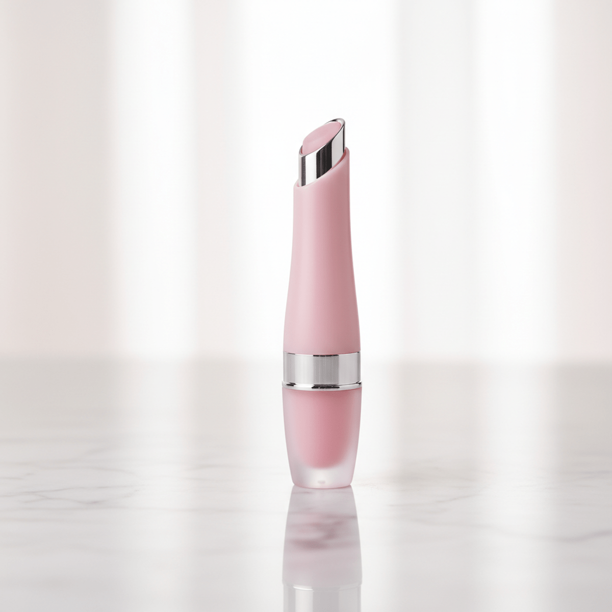 Sleek pink lip balm tube with zamac applicator on marble.