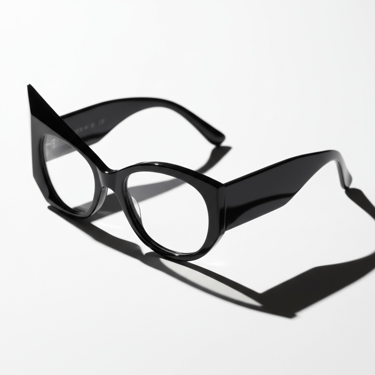 Close-up of trendy black sculptural glasses with sharp geometric and smooth curved arms.
