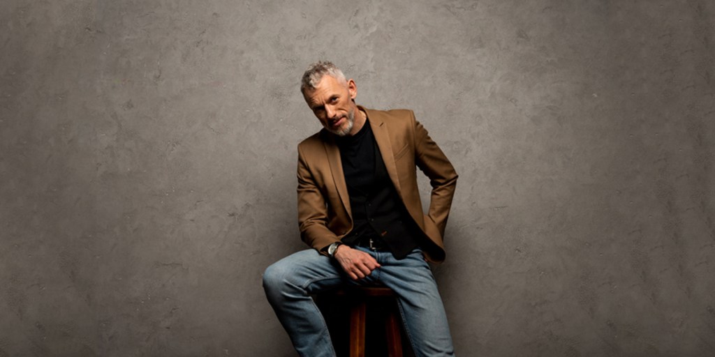 A man rocking a brown blazer and jeans