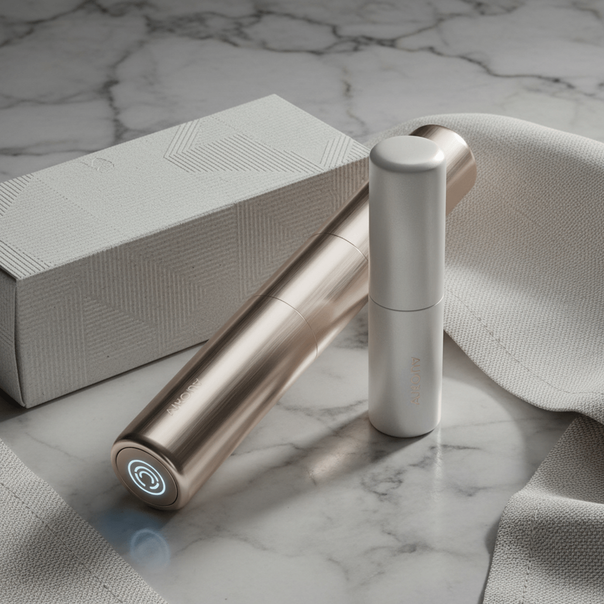 Refillable fiber mascara system on marble, showcasing metallic case and refill cartridge.