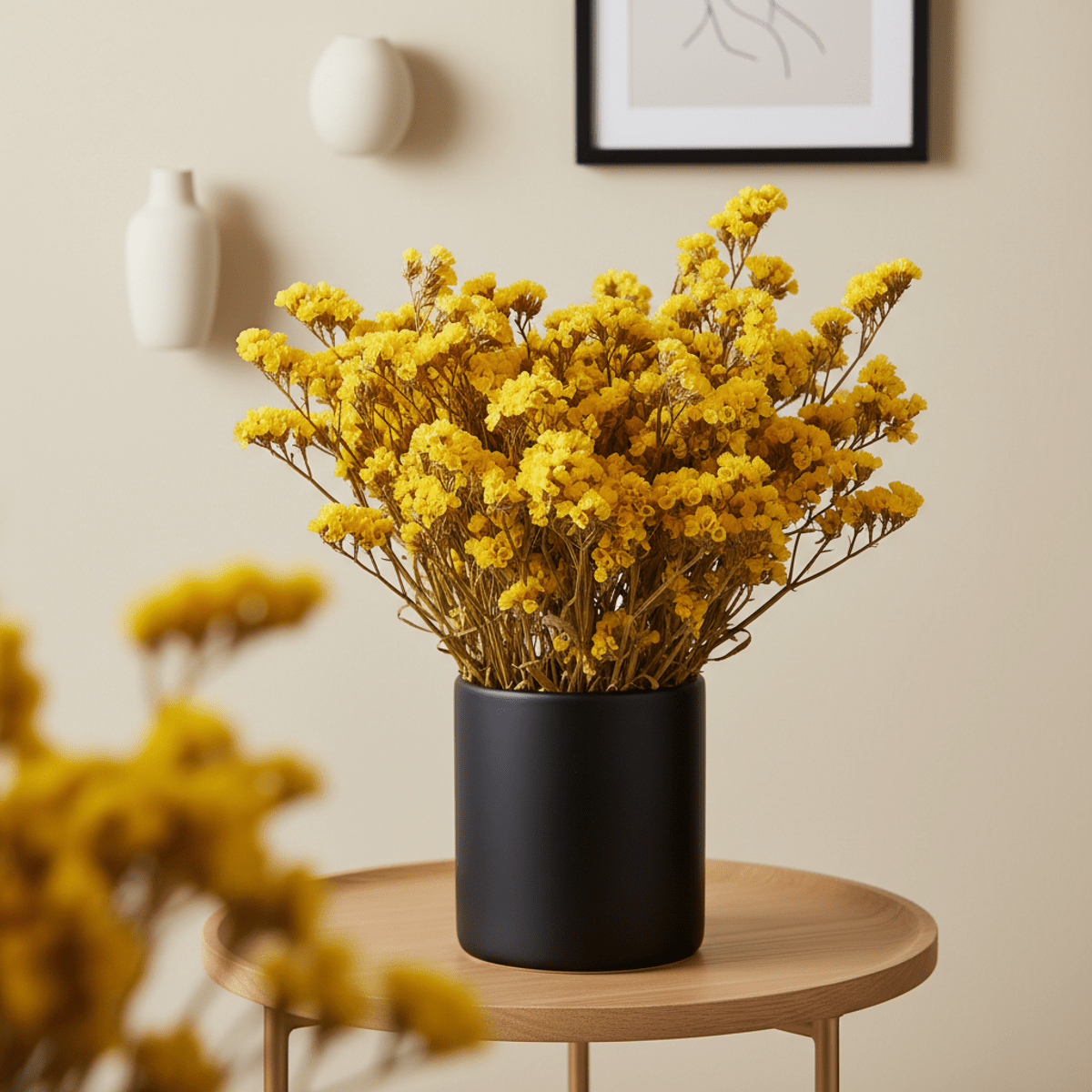 Bold arrangement of sunny yellow dried statice flowers in a matte black vase.