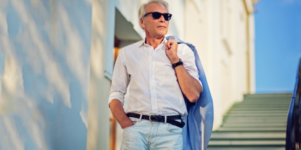A man wearing a white dress shirt and blue denim