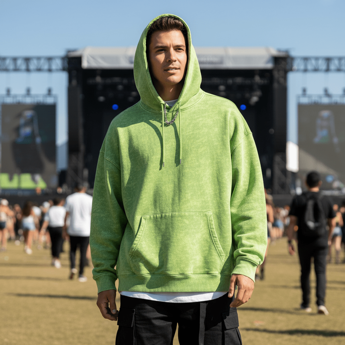 Oversized acid green hoodie with textured wash effect at an outdoor music festival.