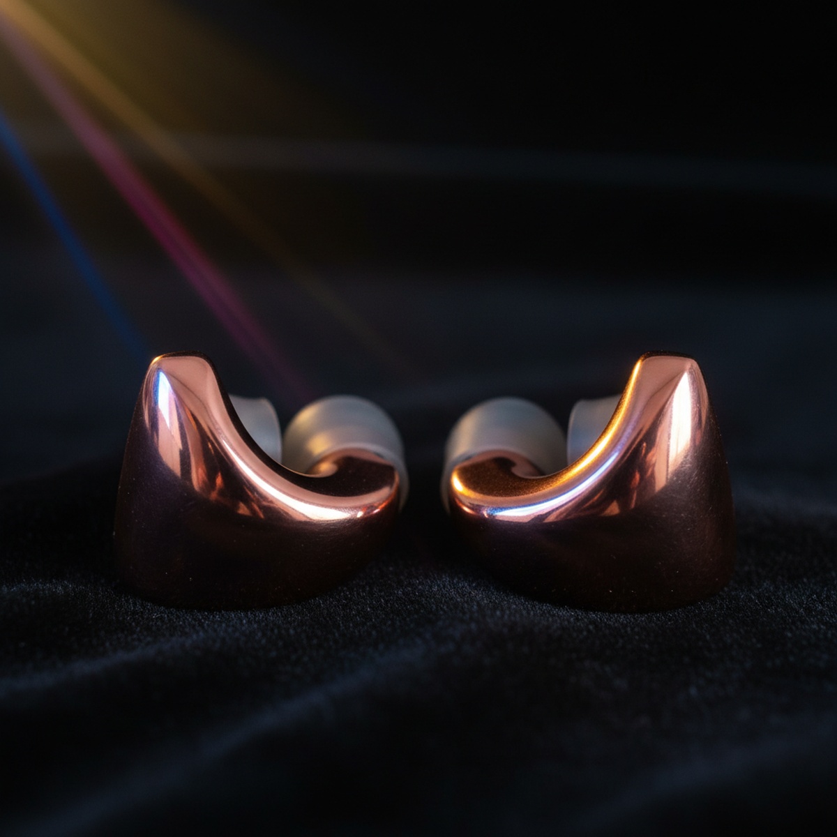 Close-up of rose gold aluminum earplugs with precision-machined surfaces on velvet.