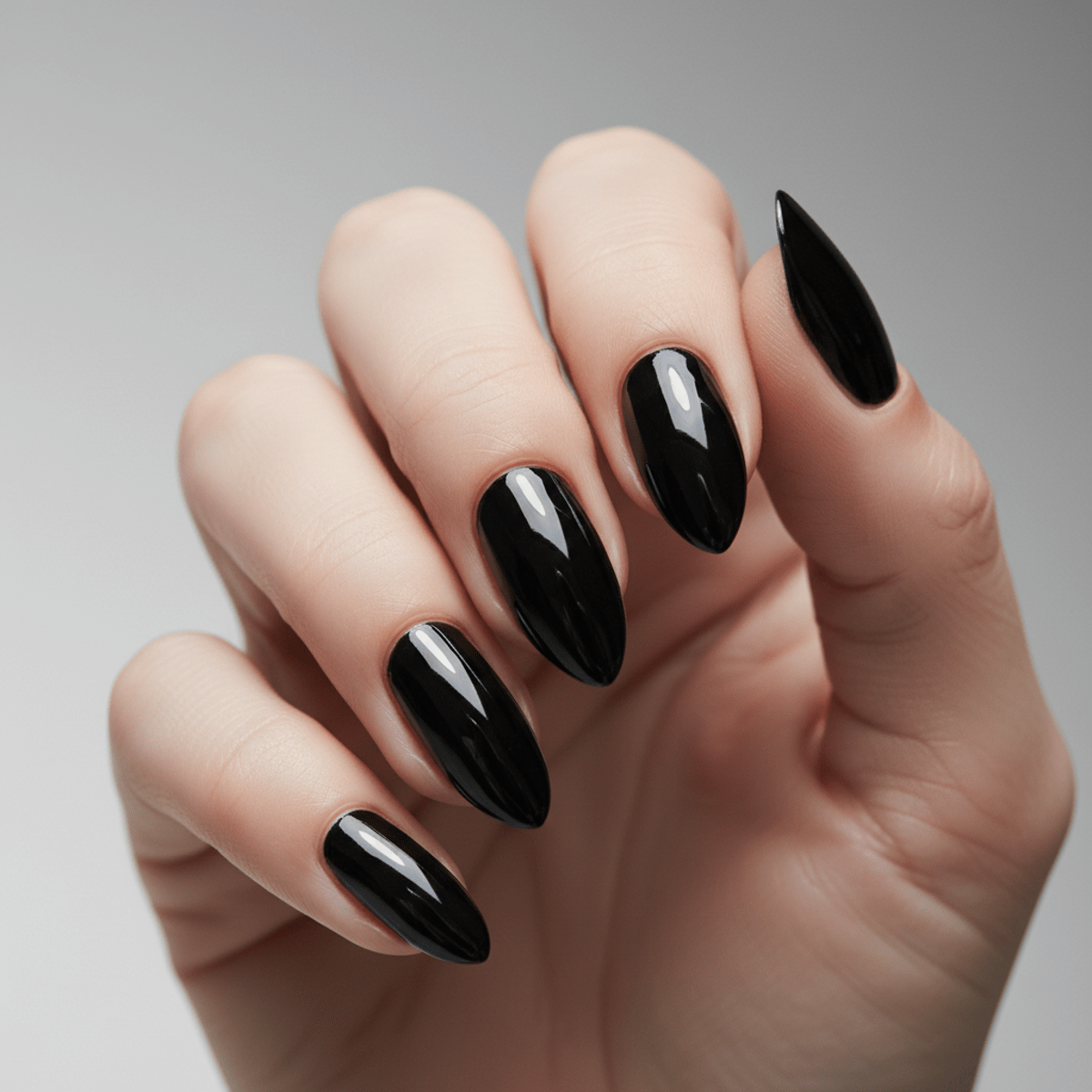 Close-up of short black chrome nails with a mirror-like molten metal effect.