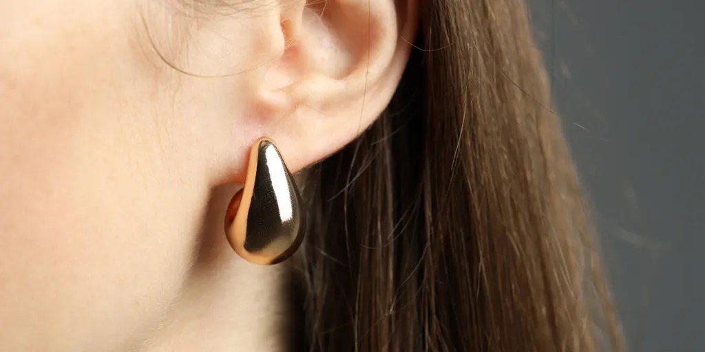 Woman wearing solid gold earrings