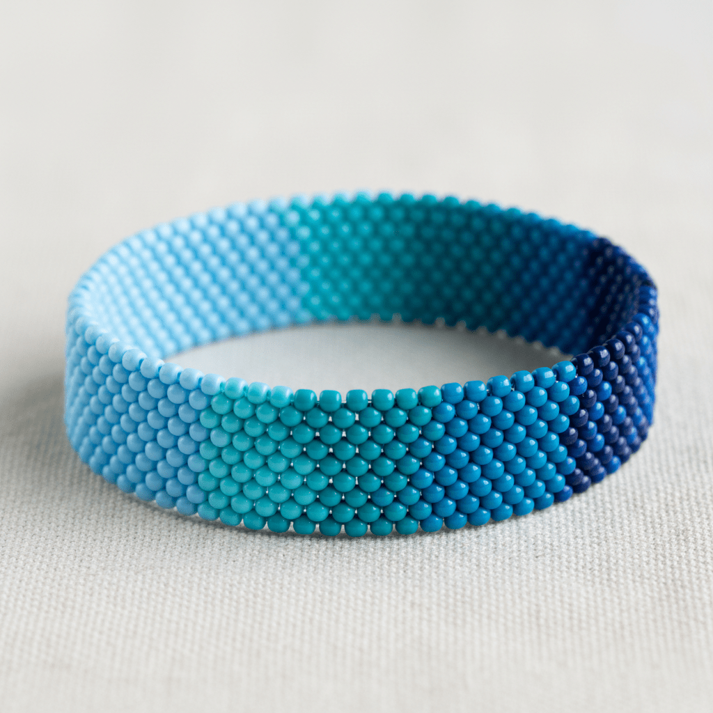 Hand-crafted friendship bracelet with ombré seed beads in blue and turquoise hues.