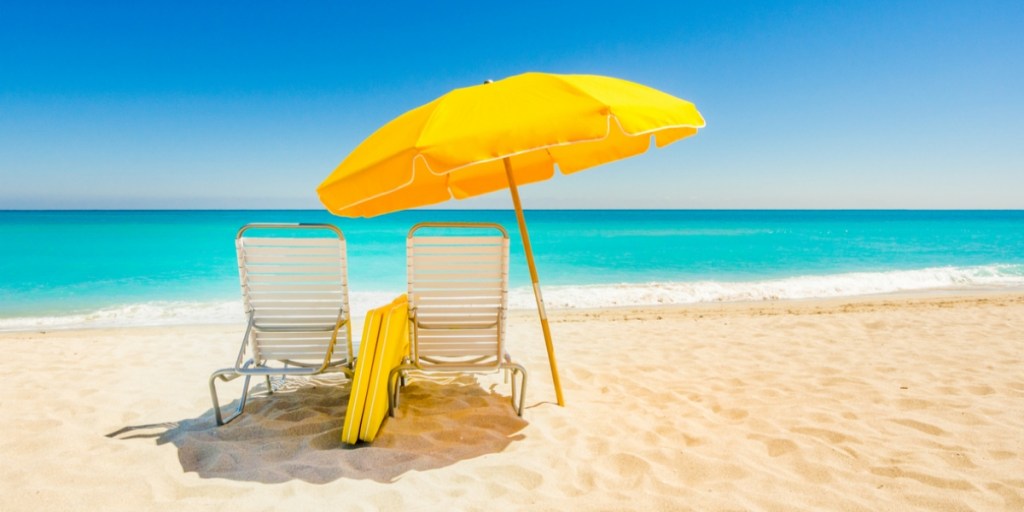 A beach umbrella covering beach chairs