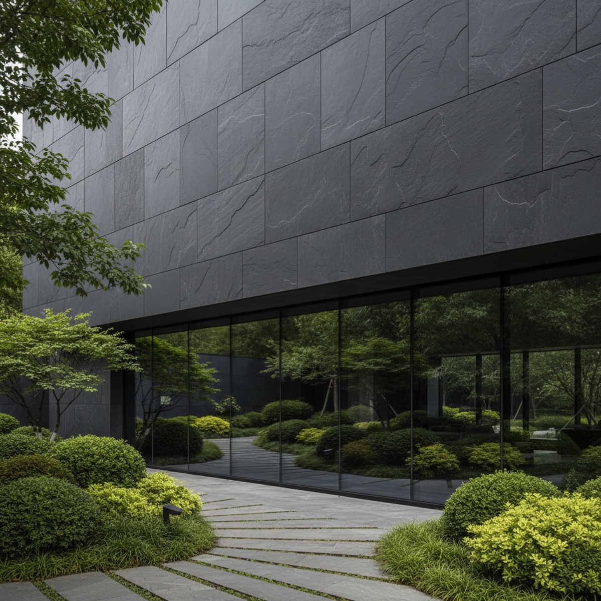 Modern building exterior with carbon slate panels and large glass windows.