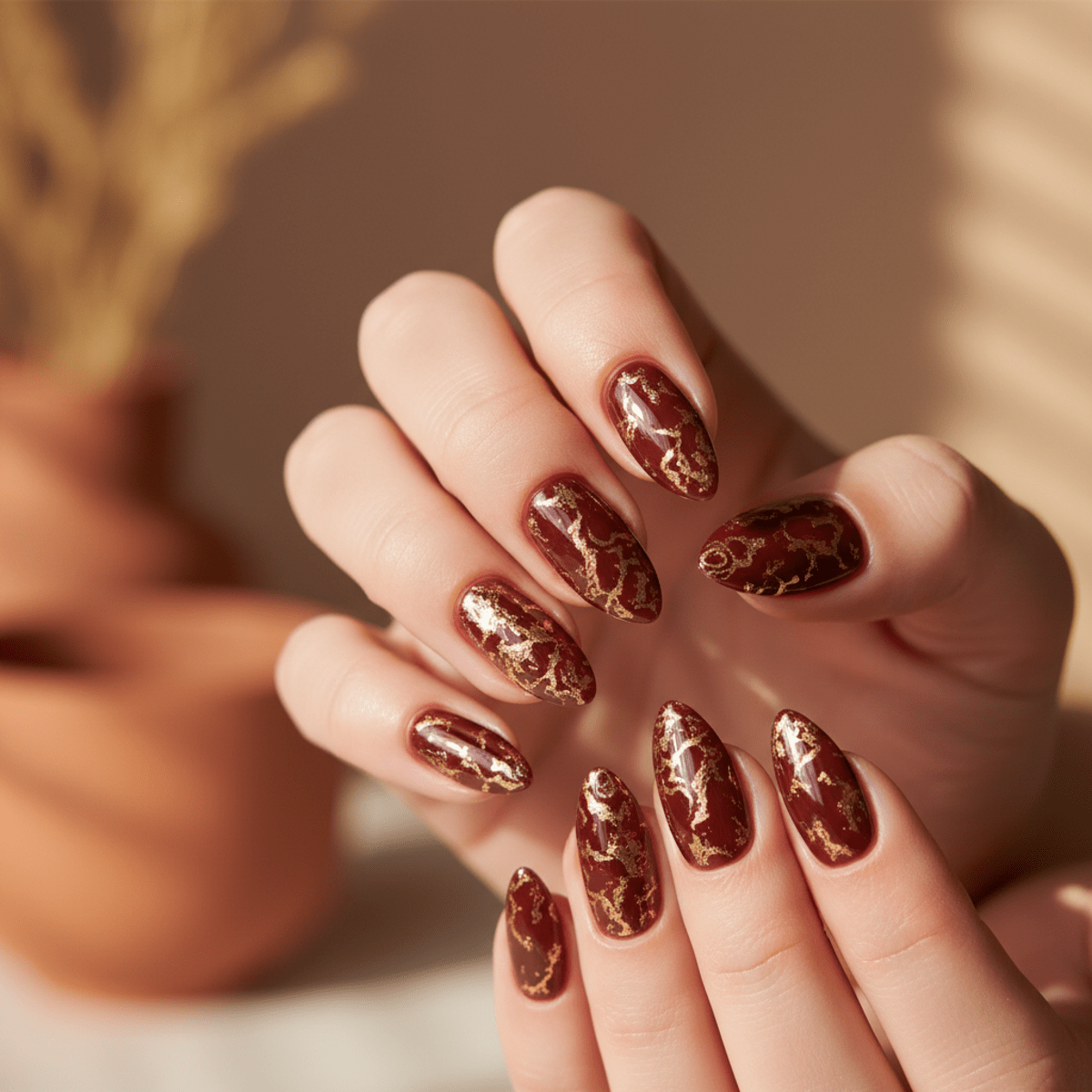 Cherry cola nails with metallic gold flakes and a glossy finish.