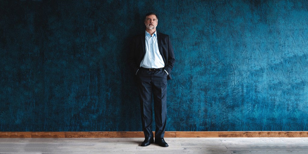 A stylish man wearing a blue tailored pair of trousers