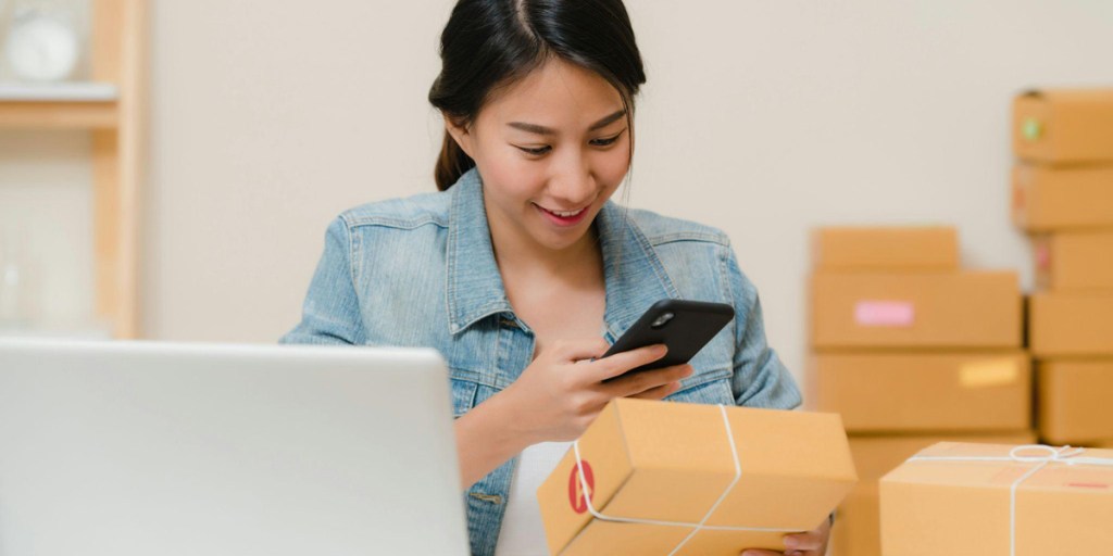 A woman photographing a brown box