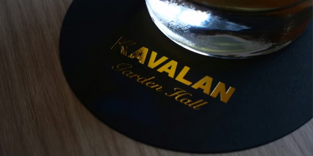 Glass of beer on top of  branded coaster