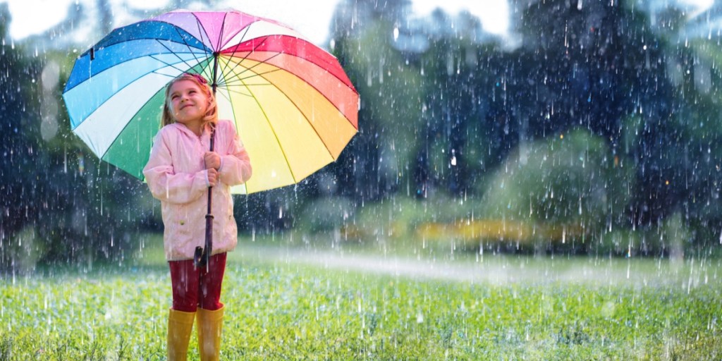 A child holding an umbrella under the rain