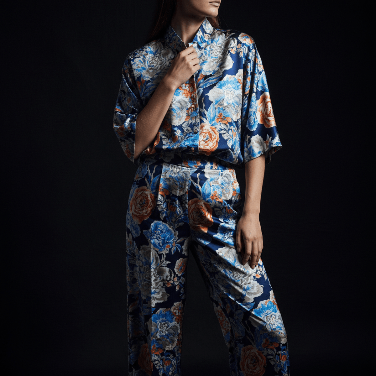 Model in flowing silk co-ord set with solarized botanical patterns and wide-leg pants.