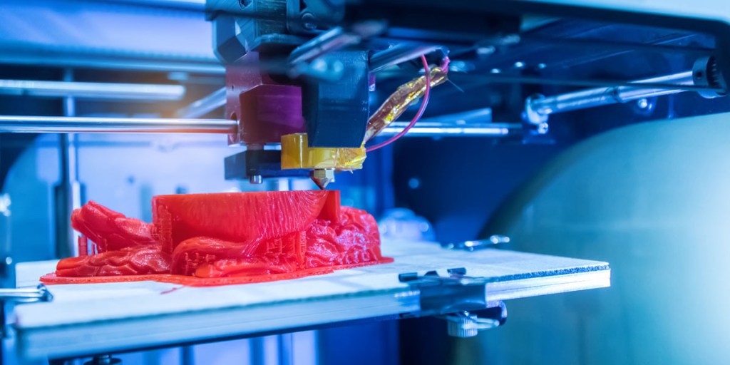 3D printer printing a red object