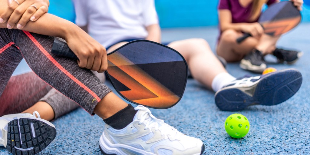 People sitting on pickleball court