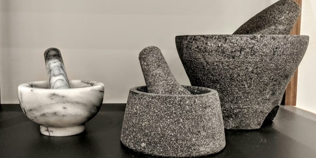 Three different sized mortar and pestles sitting on a countertop
