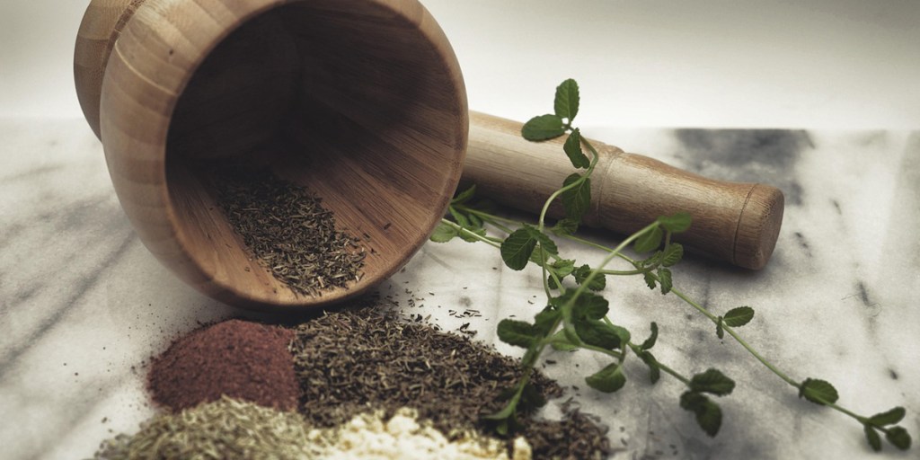 Wooden mortar on its side with spices on the counter