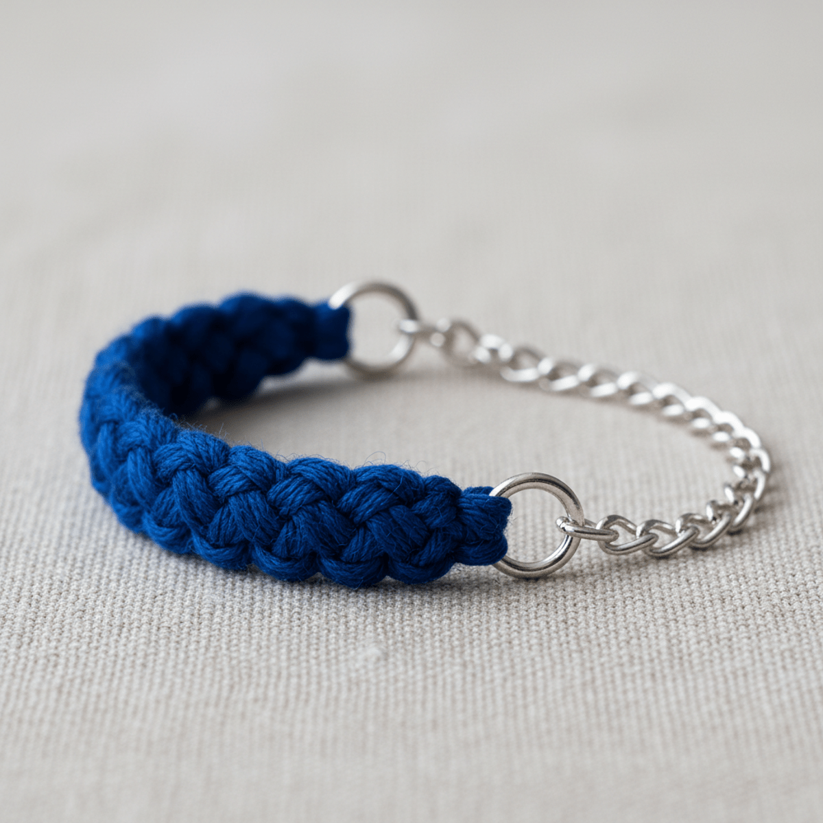 Close-up of a blue friendship bracelet, half woven thread, half silver chain.