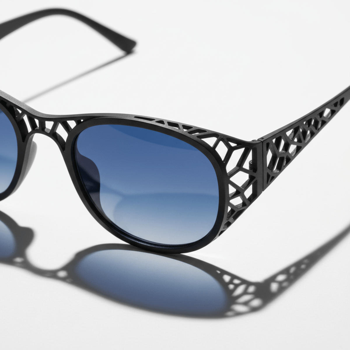 Close-up of futuristic 3D printed glasses with intricate latticework and matte black metal.