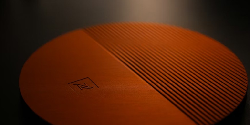 An orange designer coaster on a table