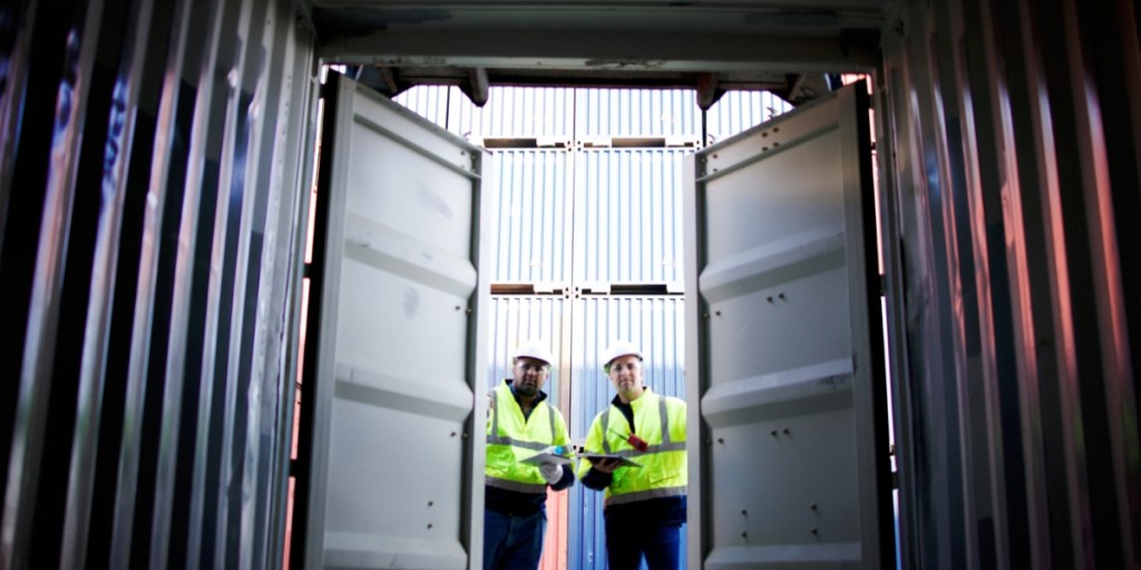 Workers opening a shipping container