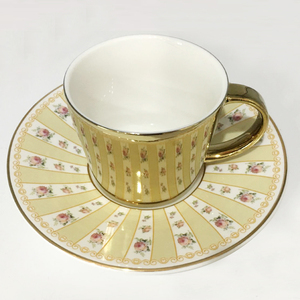 white and gold cup and saucer