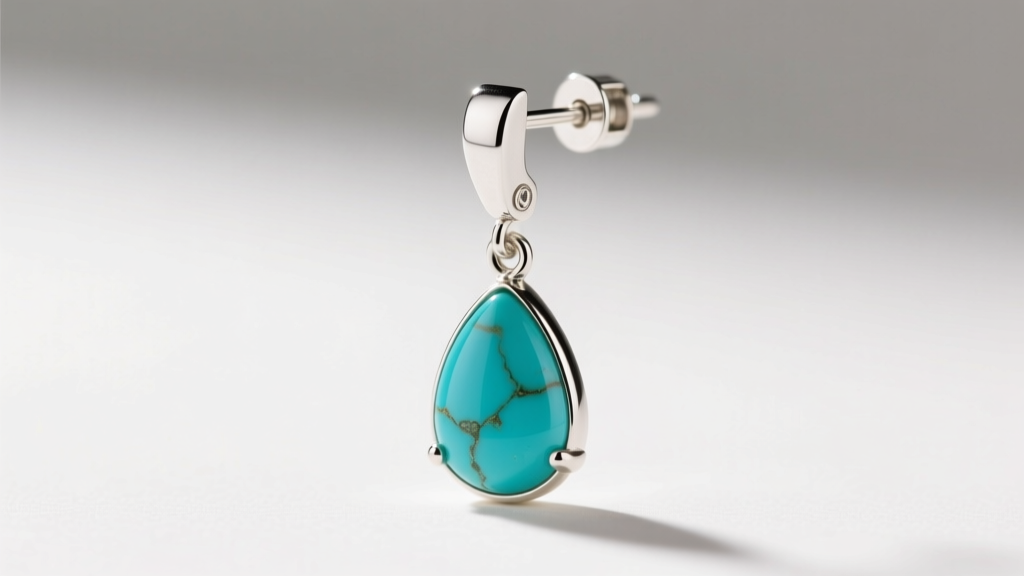 Close-up of a 20-gauge sterling silver leverback earring wire securely latched, holding a teardrop turquoise dangle in soft light.