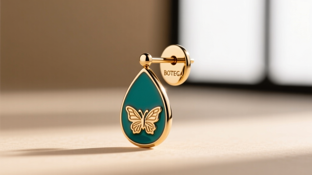Macro shot of a Bottega Veneta enamel drop earring post, showing 18-gauge thickness and an engraved logo on the butterfly back.