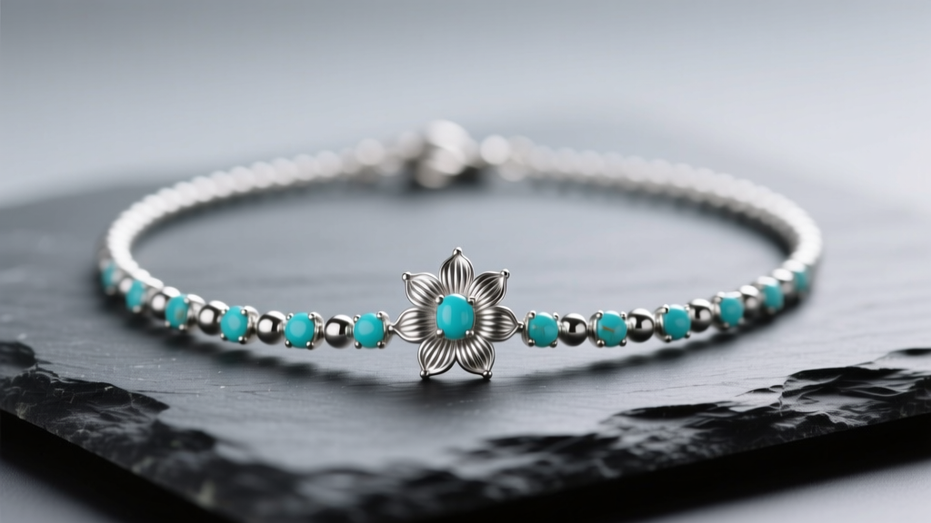 Delicate mini squash blossom necklace resting on dark slate, highlighting tiny fluted silver beads and small turquoise cabochons.