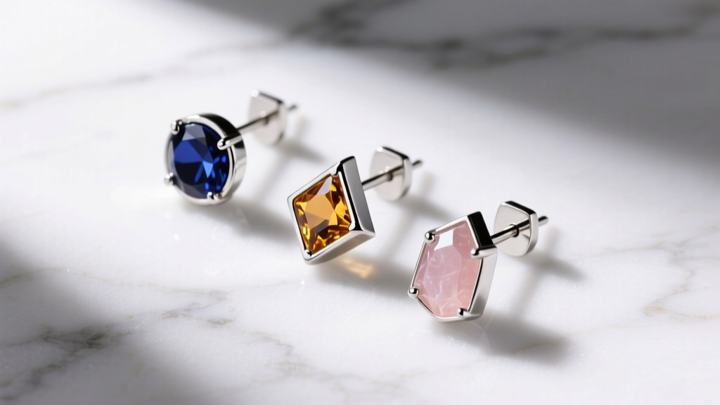 Overhead shot of three drop stud earrings with titanium posts on white marble, lit by bright studio lighting.
