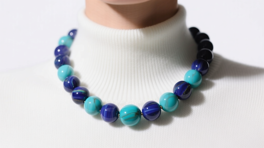 Chunky lapis and turquoise bead collar necklace displayed on a white crew-neck sweater under soft, directional studio lighting.