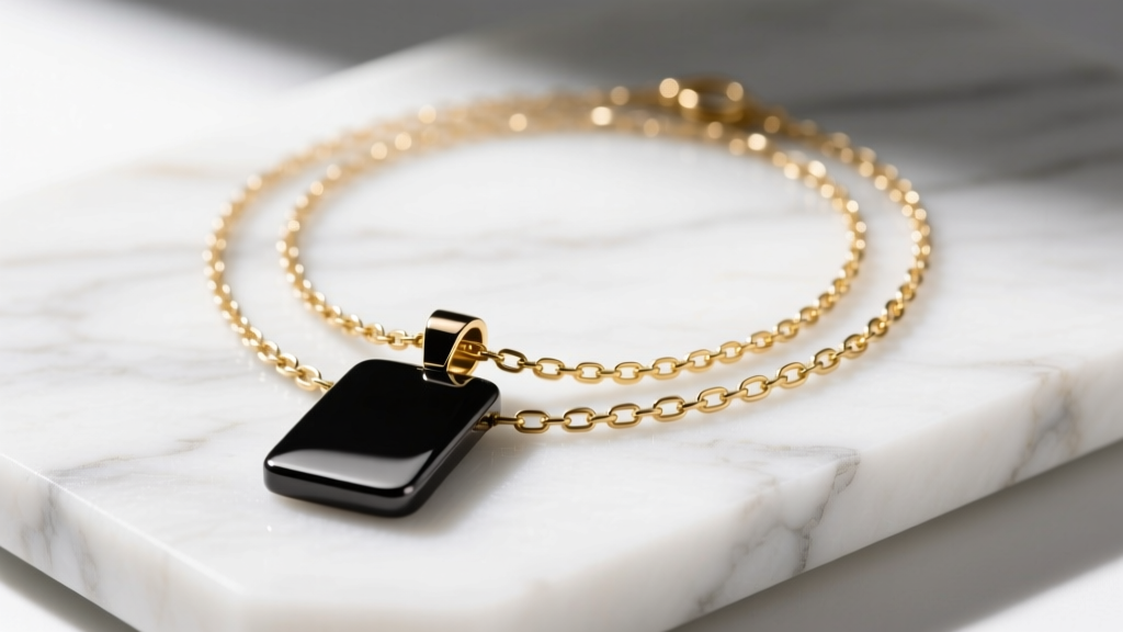 Flat lay of a layered necklace stack combining a dark Toledo steel pendant with a bright 14k gold paperclip chain on white marble.