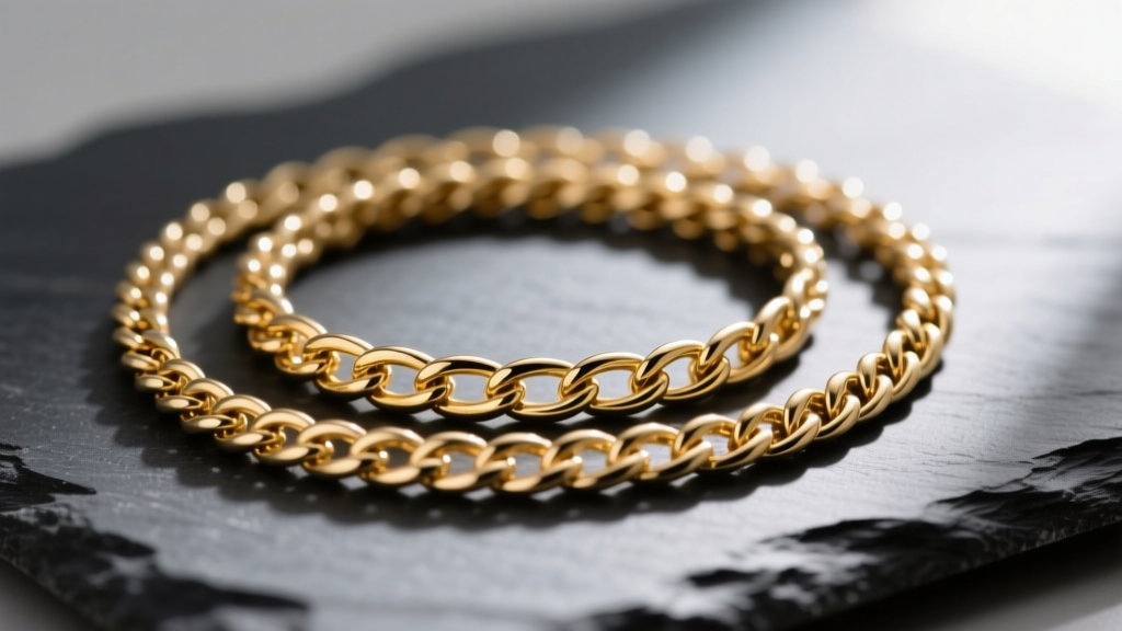Macro photography of three layered gold chains with distinct weaves resting on dark slate, highlighting link geometry and spacing.