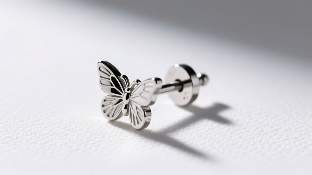 Macro shot of a 20-gauge surgical steel starter stud earring with a metal butterfly friction back resting on a white surface.