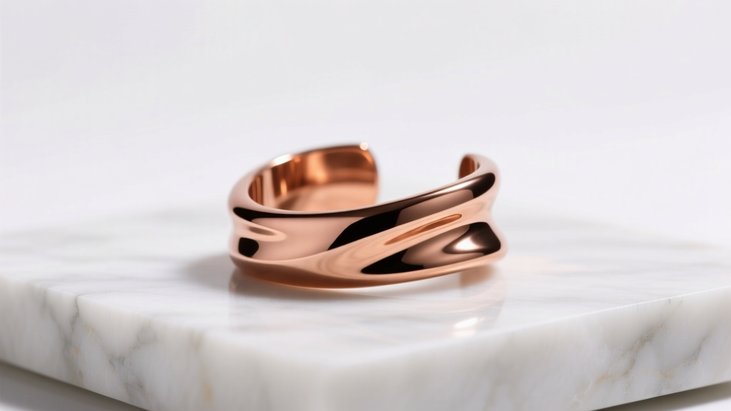 High-polish 12-gauge copper ear cuff with seamless lines resting on matte white marble under soft, directional studio lighting.