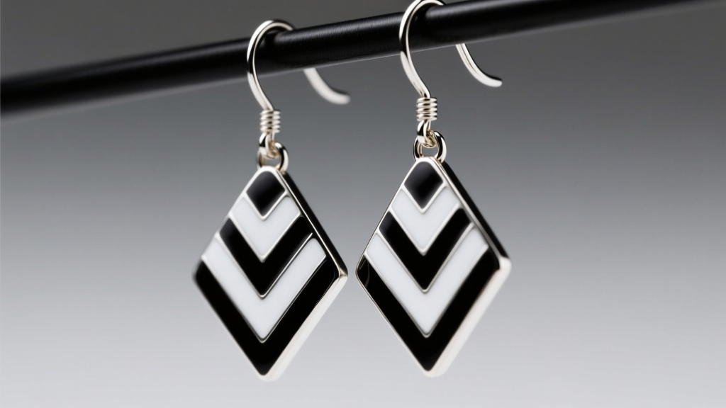Extreme close-up of black and white striped enamel dangle earrings hanging from a 20-gauge titanium fishhook, studio lighting