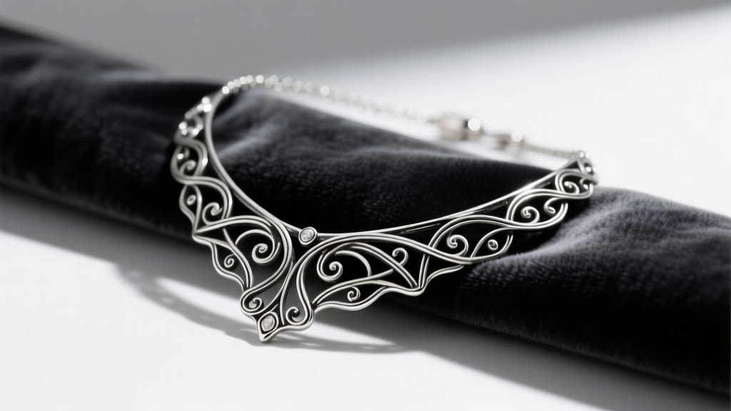 Close-up of a sterling silver Lois Hill necklace with intentional oxidation in filigree details resting on dark velvet fabric