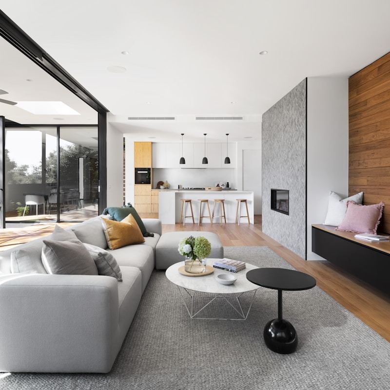 Sun-drenched living room with floor-to-ceiling windows and neutral furnishings
