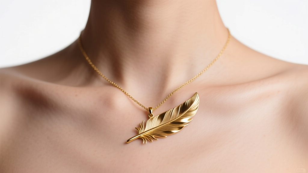 Close-up of a collarbone featuring a shiny gold metallic temporary tattoo of a delicate feather pendant on a thin chain line.