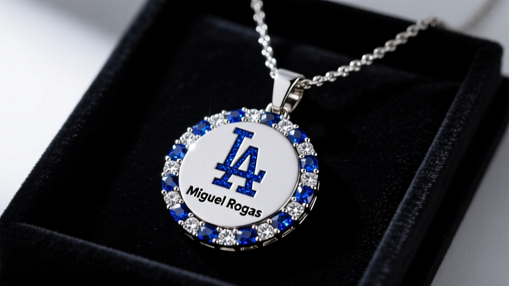 Close-up of a custom iced-out Miguel Rojas Dodgers pendant necklace resting on a dark velvet display tray under studio lighting