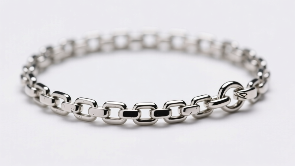 Macro shot of a 1.2mm sterling silver box chain with a slight kink, showing interlocking square links and a small lobster clasp.