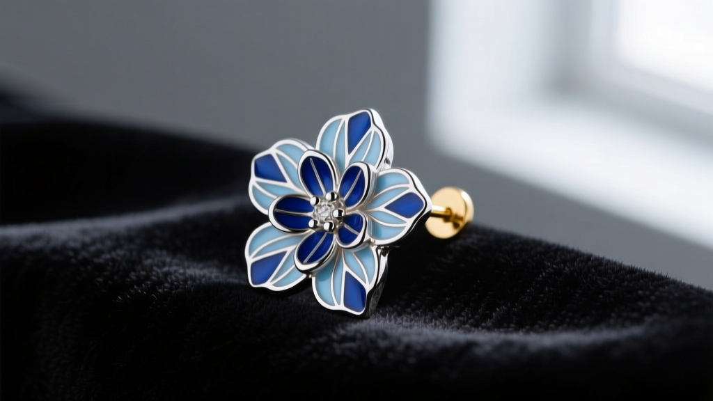Close-up of sterling silver blue guilloche enamel flower earring, showing translucent layers and an 18g post on a dark velvet cloth.
