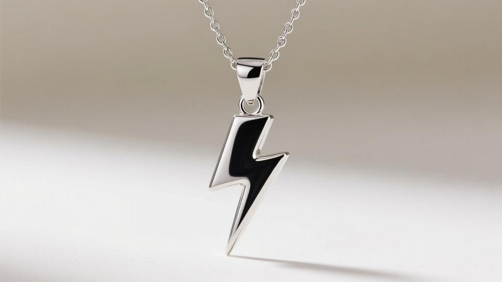 Macro photo of a sterling silver lightning bolt pendant with dark rhodium plating, showing polished edges on a 1.2mm box chain.