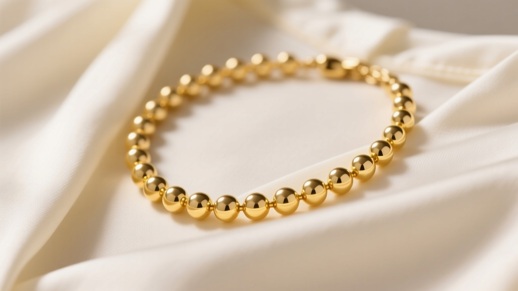 Close-up of a 14k yellow gold popcorn necklace on a silk blouse, highlighting puffed textured links under soft studio lighting.