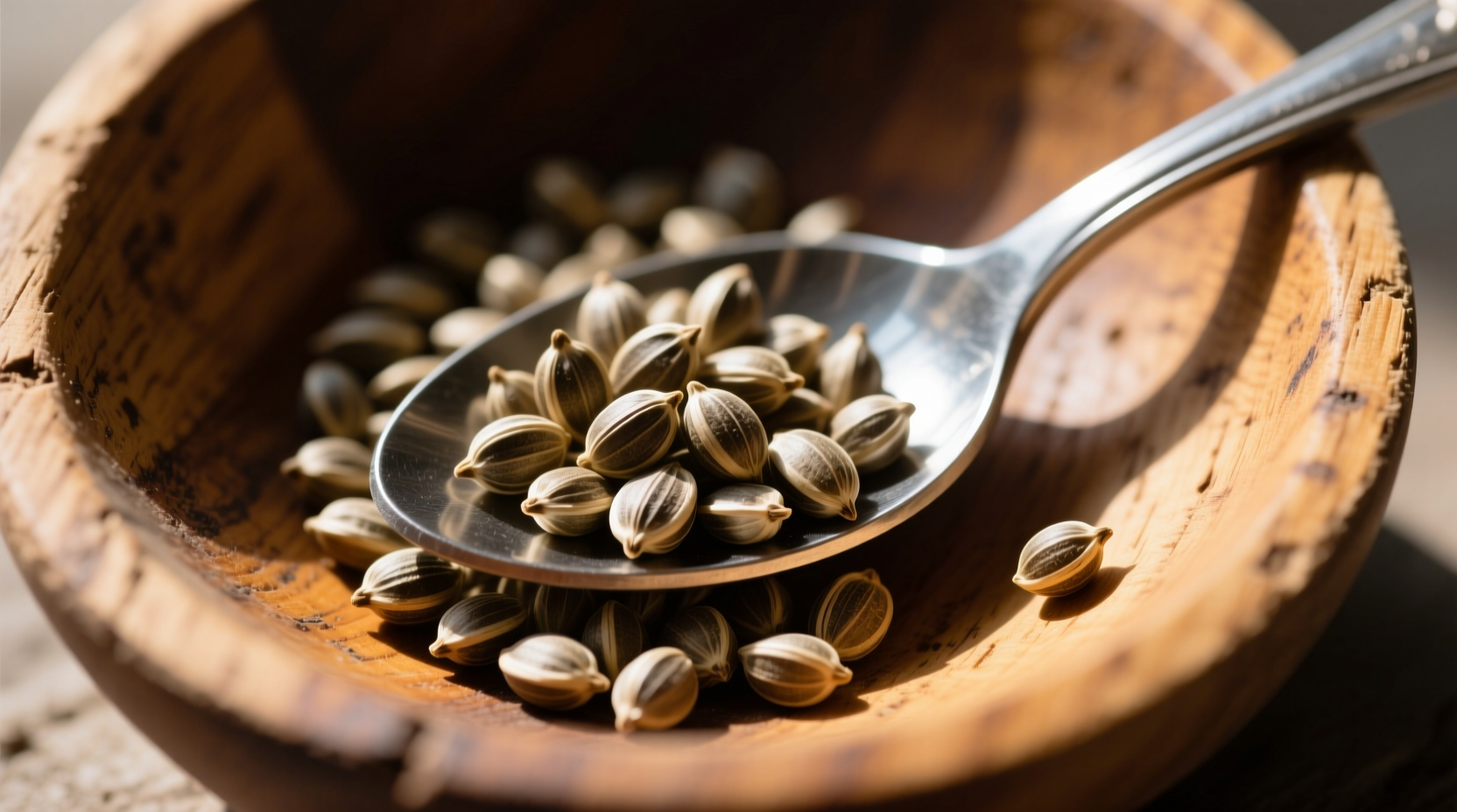 Close-up of hemp seeds in wooden bowl with spoon
